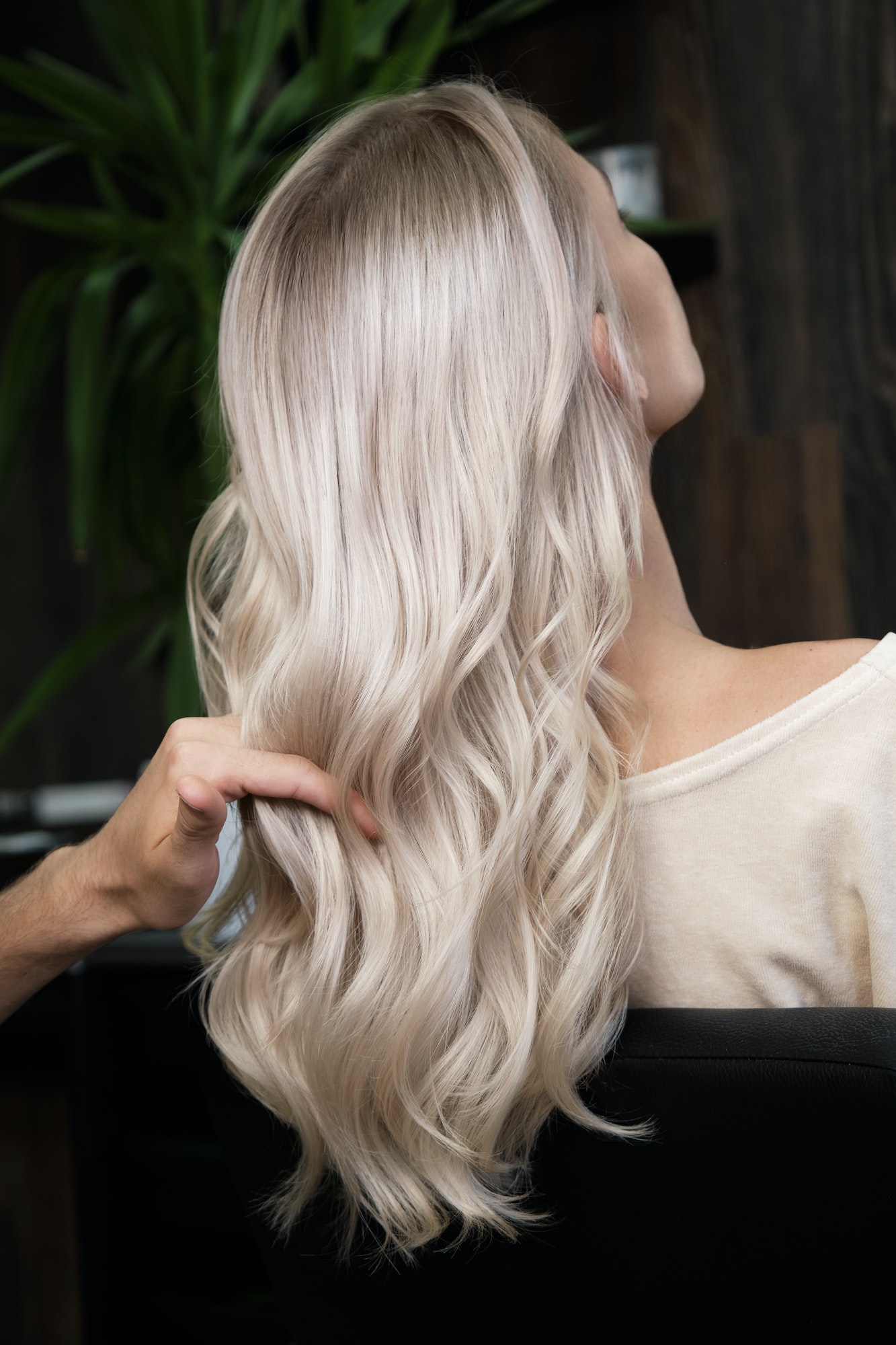 Young woman in a hairdressing salon dyes her hair blond